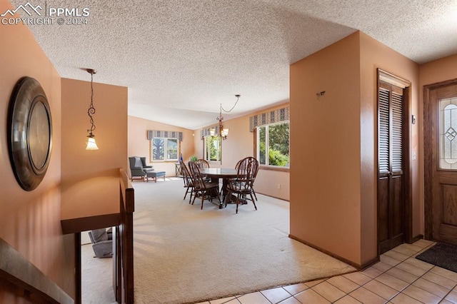 dining area featuring a textured ceiling, a chandelier, light colored carpet, and vaulted ceiling