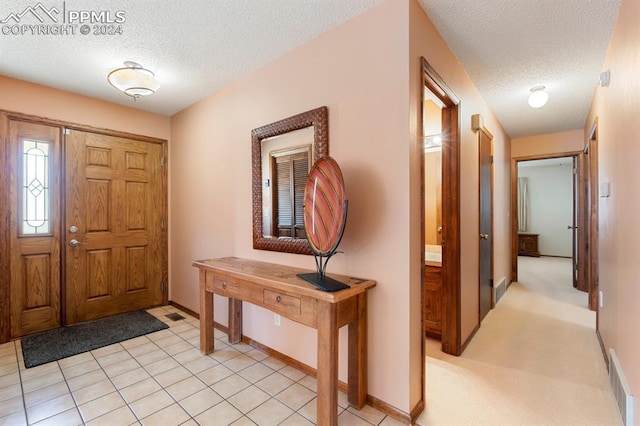 tiled foyer with a textured ceiling