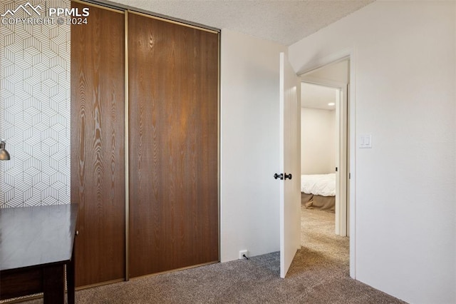 unfurnished bedroom featuring a closet, light colored carpet, and a textured ceiling