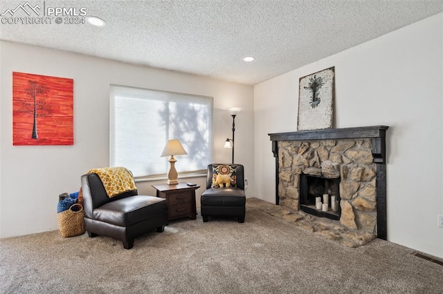 sitting room featuring a textured ceiling, carpet floors, and a fireplace