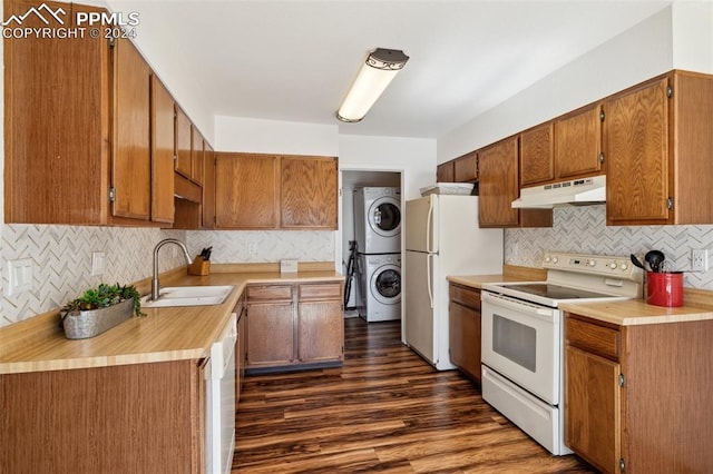 kitchen with sink, dark hardwood / wood-style floors, stacked washer / dryer, white appliances, and decorative backsplash