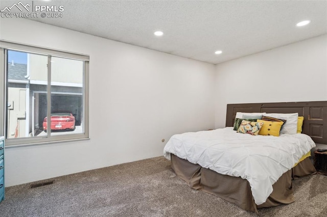 carpeted bedroom with a textured ceiling