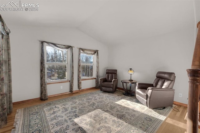 sitting room with light wood-type flooring and lofted ceiling