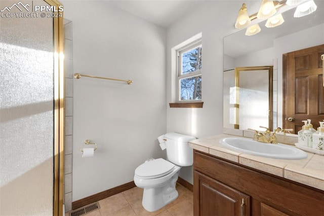 bathroom featuring tile patterned flooring, vanity, an enclosed shower, and toilet