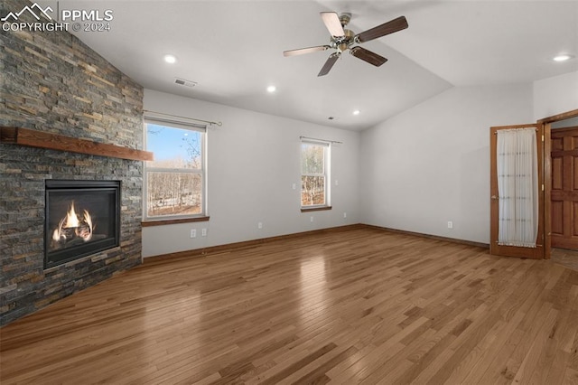 unfurnished living room with a fireplace, hardwood / wood-style flooring, vaulted ceiling, and ceiling fan