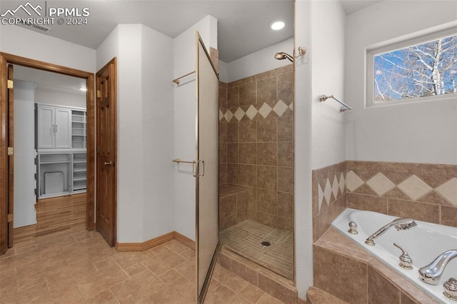 bathroom featuring shower with separate bathtub