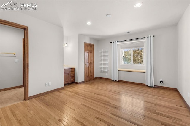 unfurnished bedroom featuring light hardwood / wood-style floors and ensuite bathroom