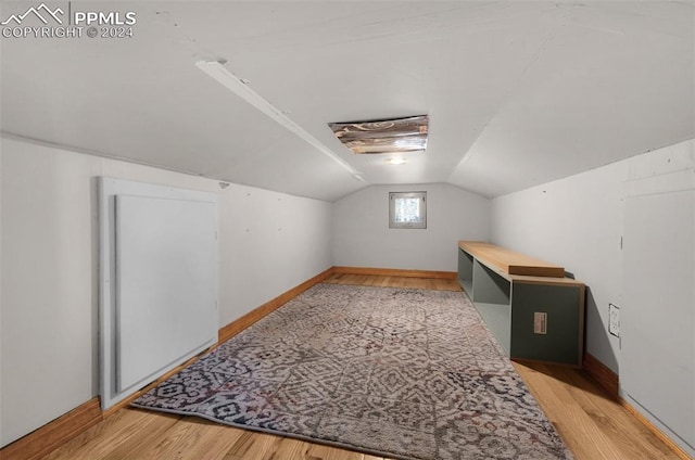 additional living space with light wood-type flooring and vaulted ceiling