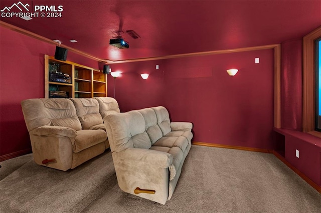 carpeted home theater featuring crown molding