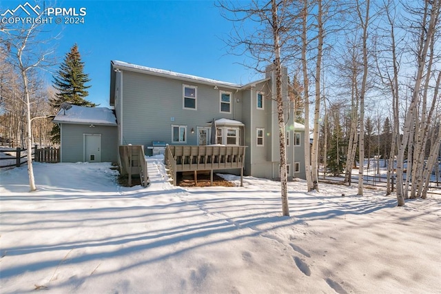 snow covered house with a deck