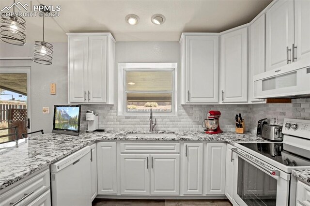 kitchen with white cabinetry, pendant lighting, and white appliances