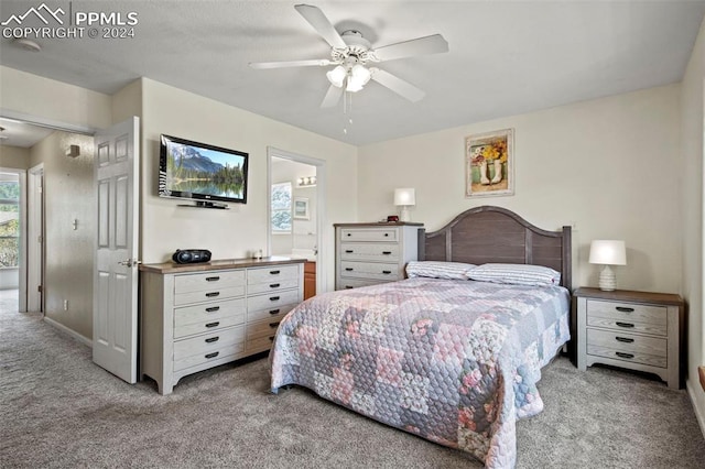 bedroom with ceiling fan, ensuite bathroom, and light carpet