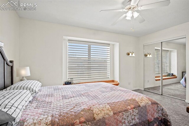 carpeted bedroom featuring ceiling fan and a closet