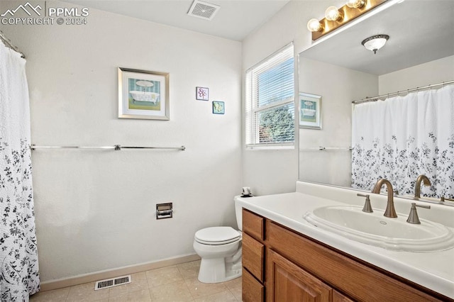 bathroom featuring tile patterned flooring, vanity, and toilet