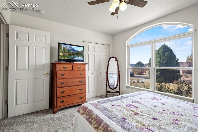 bedroom with light carpet, a textured ceiling, a closet, and ceiling fan