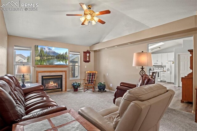 carpeted living room with a fireplace, ceiling fan, and lofted ceiling