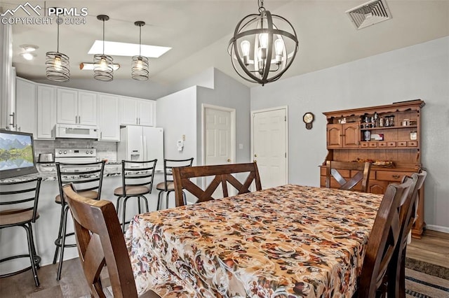 dining area with dark hardwood / wood-style floors and a notable chandelier