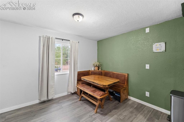 dining room featuring a textured ceiling and hardwood / wood-style flooring