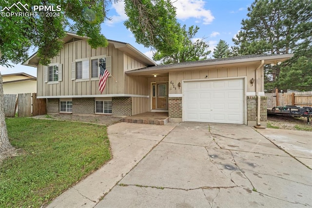 split level home with a garage and a front yard