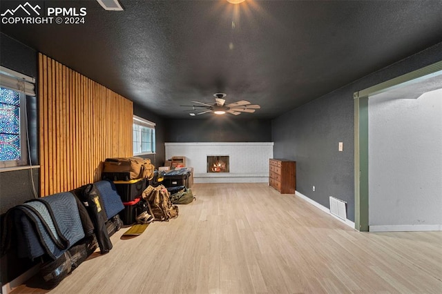 interior space with ceiling fan, light hardwood / wood-style floors, and a textured ceiling