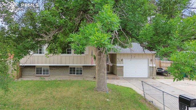 split level home featuring a front yard and a garage