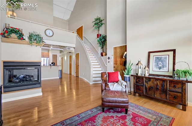 living area featuring hardwood / wood-style floors and a high ceiling