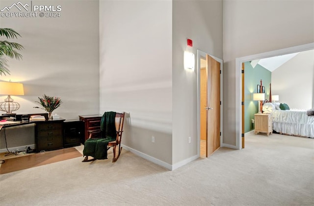 living area with light carpet and high vaulted ceiling