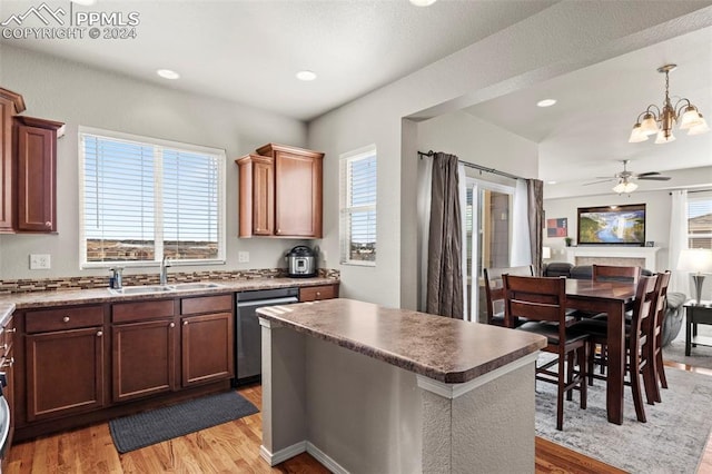 kitchen with dishwasher, hanging light fixtures, ceiling fan with notable chandelier, and light hardwood / wood-style flooring