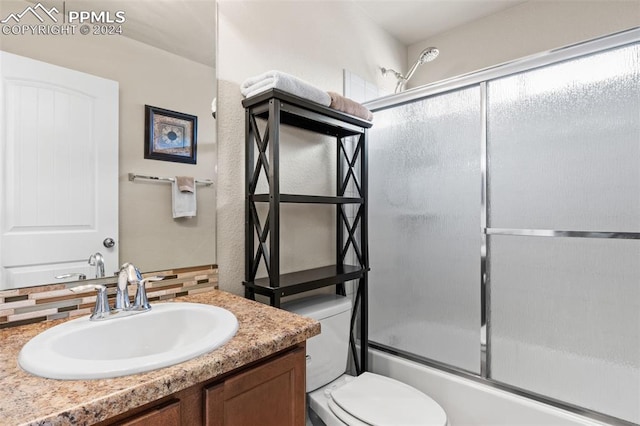 full bathroom with vanity, toilet, enclosed tub / shower combo, and backsplash