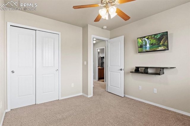 unfurnished bedroom featuring ceiling fan, light colored carpet, and a closet