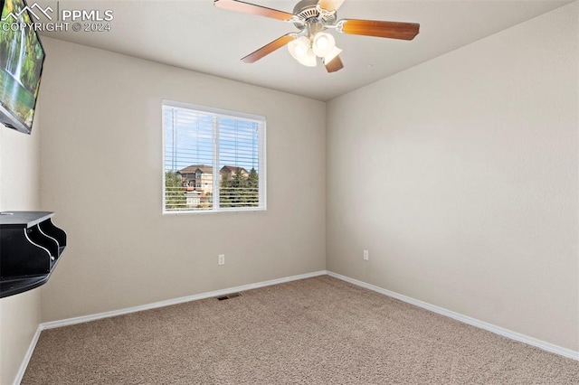 carpeted spare room featuring ceiling fan