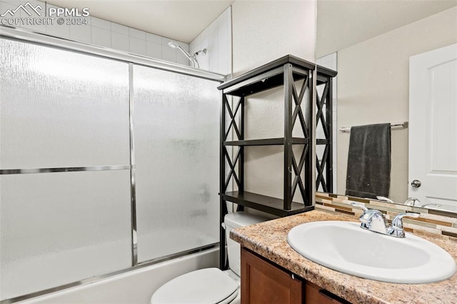 full bathroom with vanity, toilet, and enclosed tub / shower combo