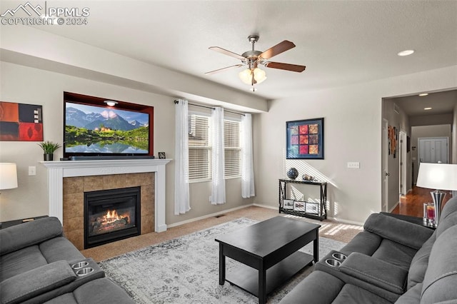 carpeted living room with a fireplace and ceiling fan