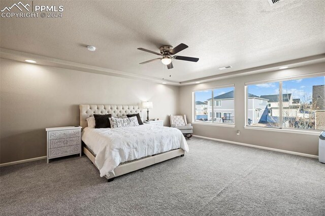 carpeted bedroom featuring ceiling fan and a textured ceiling