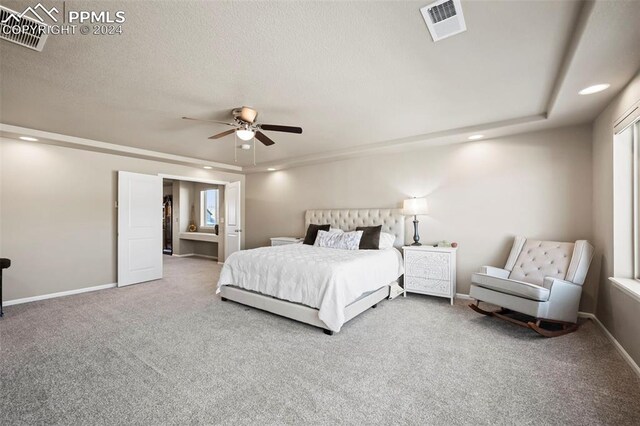 carpeted bedroom with ceiling fan and a textured ceiling