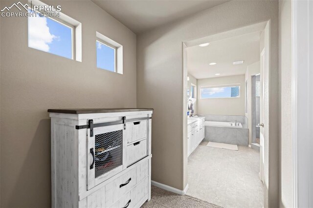 bathroom featuring vanity and tiled bath