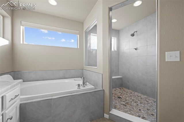 bathroom featuring vanity and shower with separate bathtub