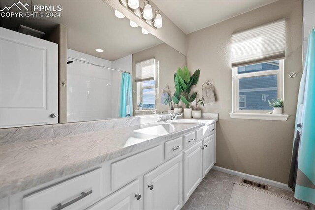 bathroom featuring tile patterned flooring, a shower with curtain, and vanity