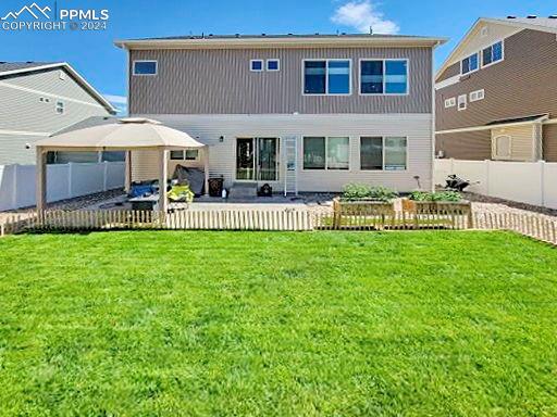 rear view of house featuring a patio area and a yard