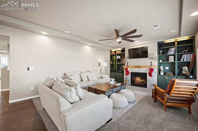 living room with hardwood / wood-style flooring, ceiling fan, and a fireplace