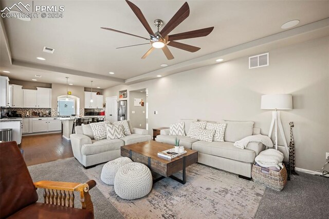 living room featuring hardwood / wood-style floors and ceiling fan