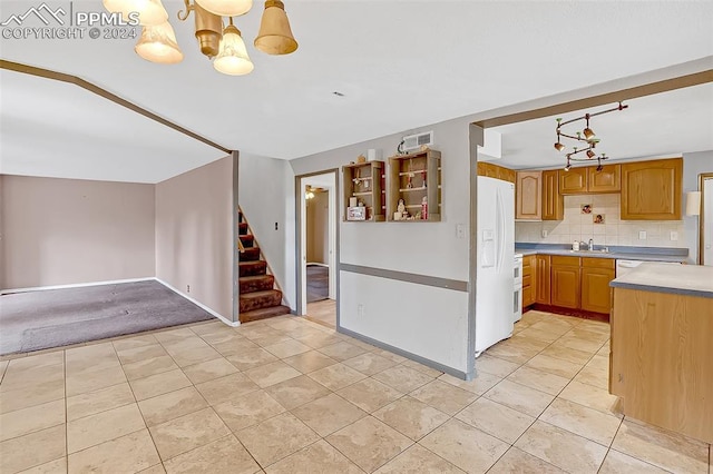 kitchen featuring sink, white refrigerator with ice dispenser, a notable chandelier, backsplash, and pendant lighting