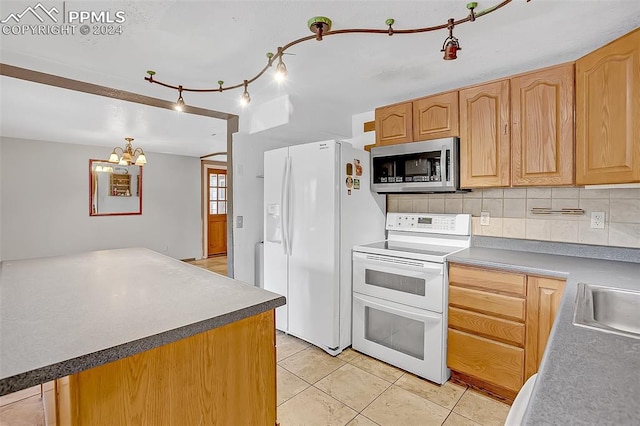 kitchen featuring light brown cabinetry, backsplash, white appliances, light tile patterned floors, and an inviting chandelier