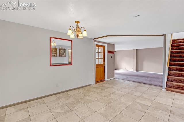 empty room featuring light carpet and an inviting chandelier