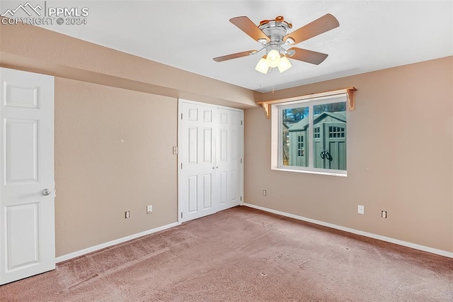 unfurnished bedroom with ceiling fan, a closet, and carpet floors