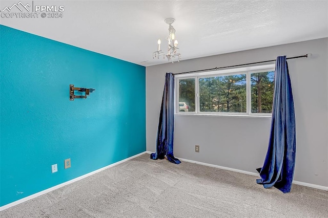 carpeted spare room with a notable chandelier