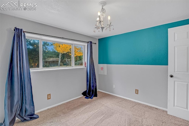 spare room with carpet floors, vaulted ceiling, and an inviting chandelier