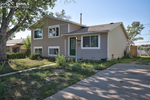 tri-level home with a front yard