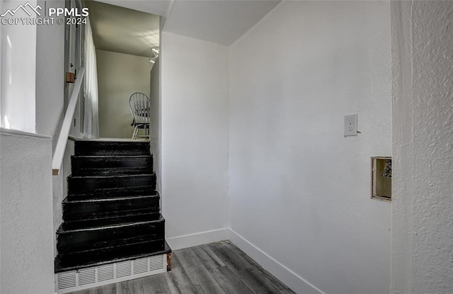 staircase with hardwood / wood-style flooring