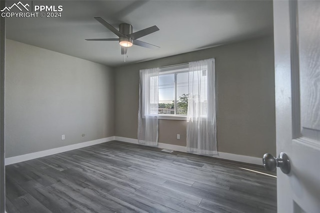 spare room with ceiling fan and dark wood-type flooring